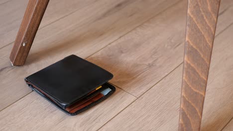 black leather wallet on wooden floor