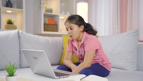 la niña que mira la computadora portátil se frustra.