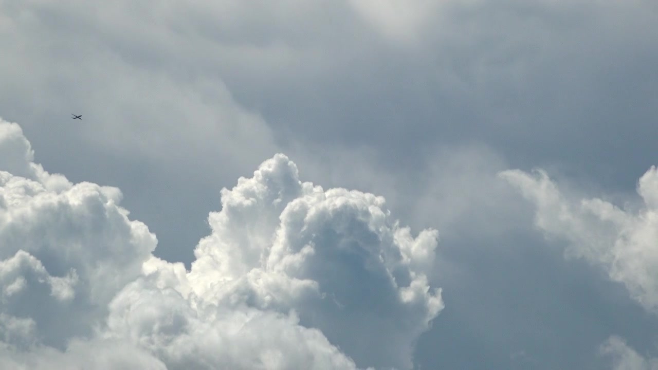 Selang waktu (time lapse) pesawat penumpang melintas di depan awan badai Cumulus Nimbus yang mengepul