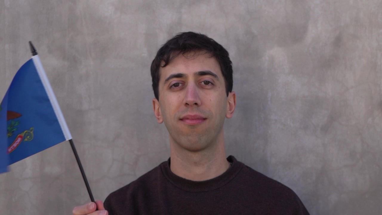 Persona che sventola la bandiera dello stato del Dakota del Nord al rallentatore. Primo piano.