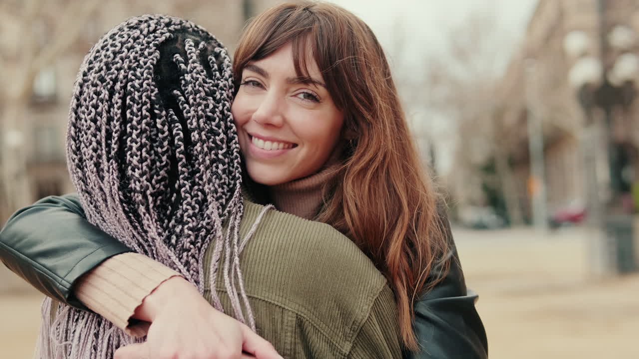 Due giovani donne felici che si abbracciano all'aperto