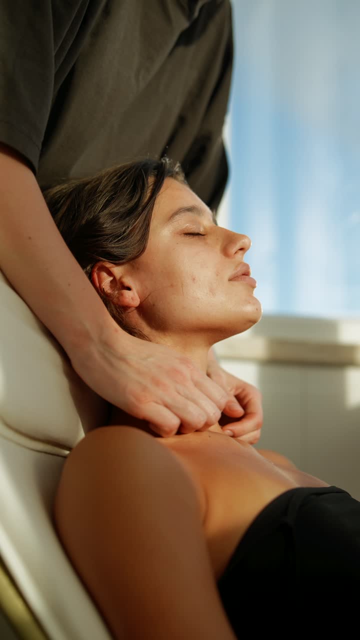 Ung kvinde modtager afslappende nakke- og skuldermassage i spa