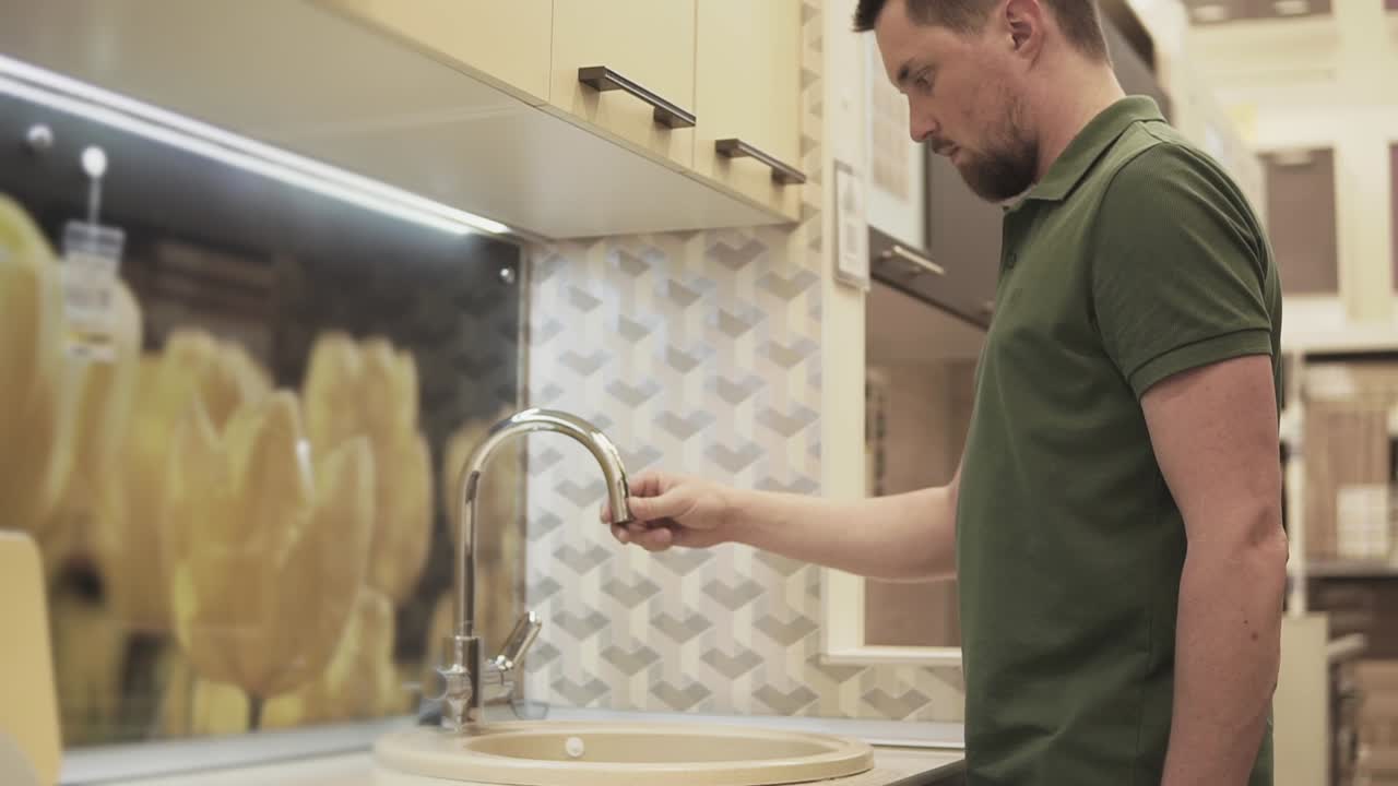hombre comprobando un fregadero de cocina en una tienda de artículos para el hogar