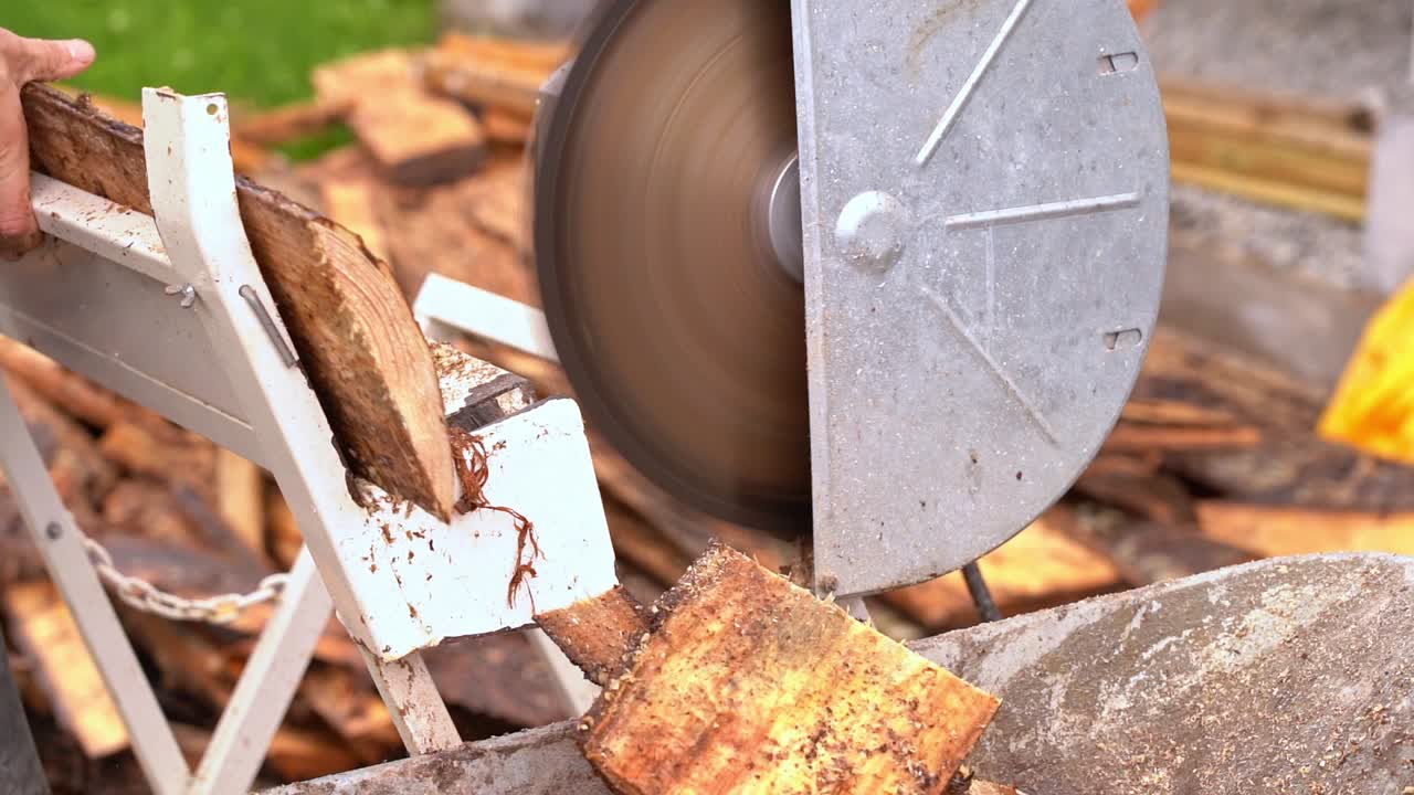 슬로우 모션 크로스컷은 나무 소나무 널빤지에서 장작을 자르는 것을 보았습니다 - 톱과 나무가 손수레에 떨어지는 것을 20% 느린 동작과 흐릿한 배경