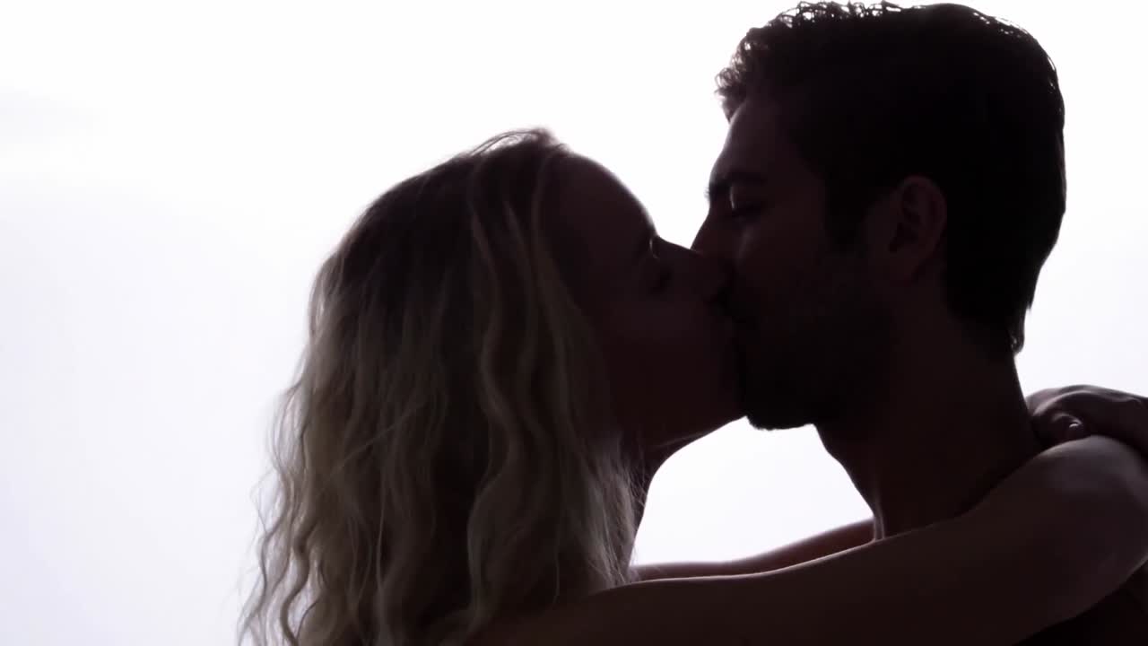 пара стоит и целуется.