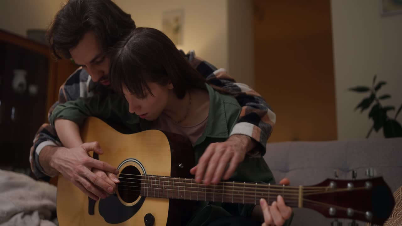 Couple playing guitar together