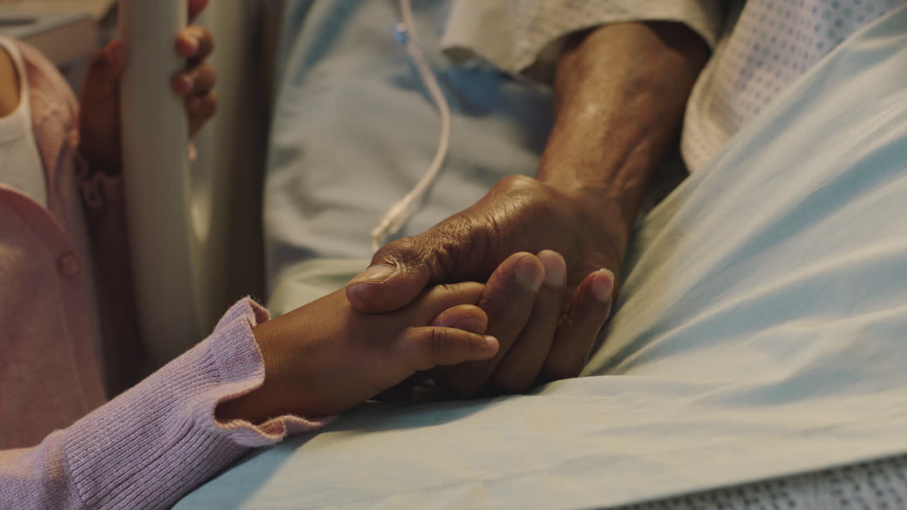 niña sosteniendo la mano de los abuelos abuelo acostado en la cama del hospital niño mostrando afecto al lado de la cama para el abuelo recuperándose de la enfermedad atención médica apoyo familiar