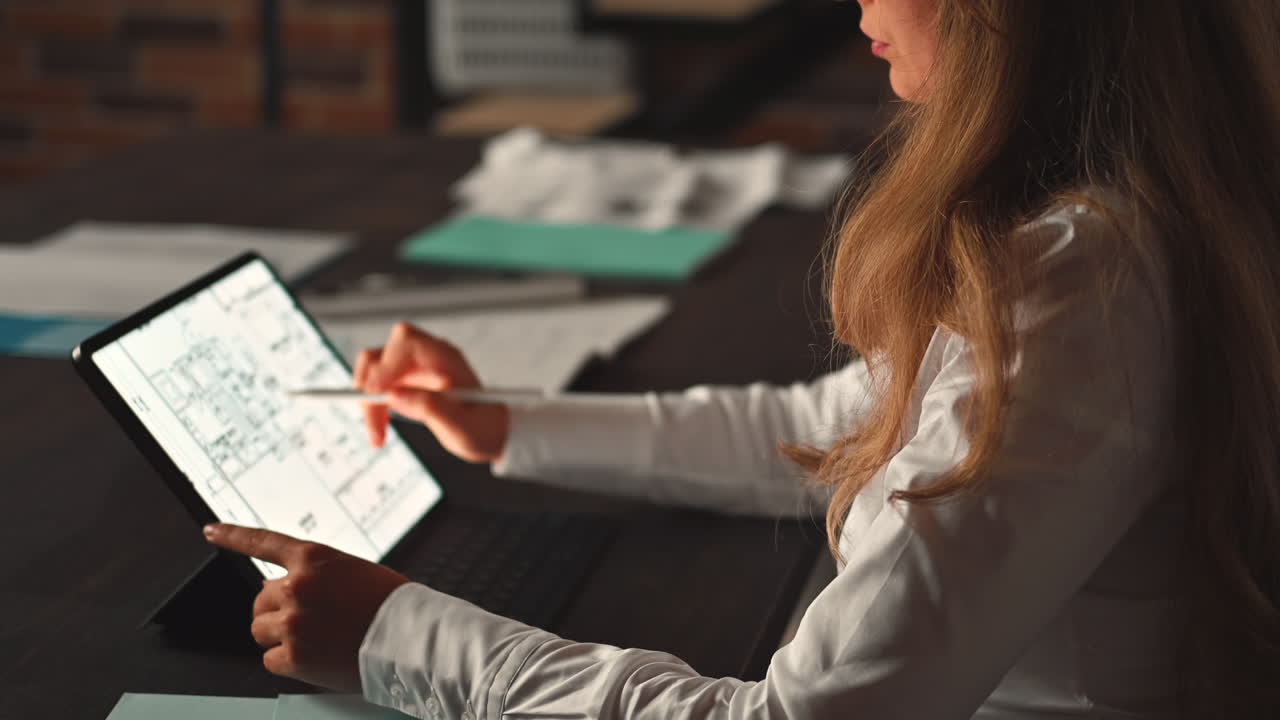 Woman working on a tablet with a stylus pen at an office