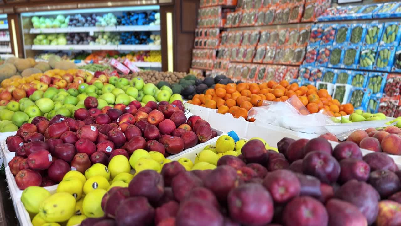 Vibrant 4K footage of apples, oranges, avocados, and more stacked in a fresh produce market. Ideal for food, retail, health, and nutrition-themed video projects.