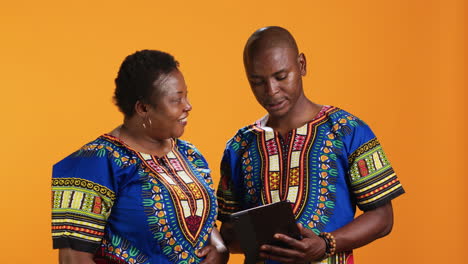 ethnic couple navigating on social media app using tablet