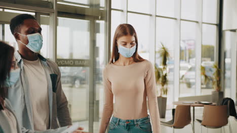 personas con máscaras en un concesionario de automóviles