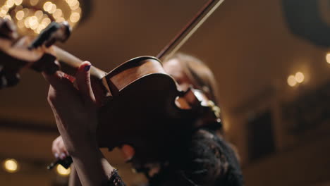 female violinist is playing music closeup view of old expensive violin and female hands