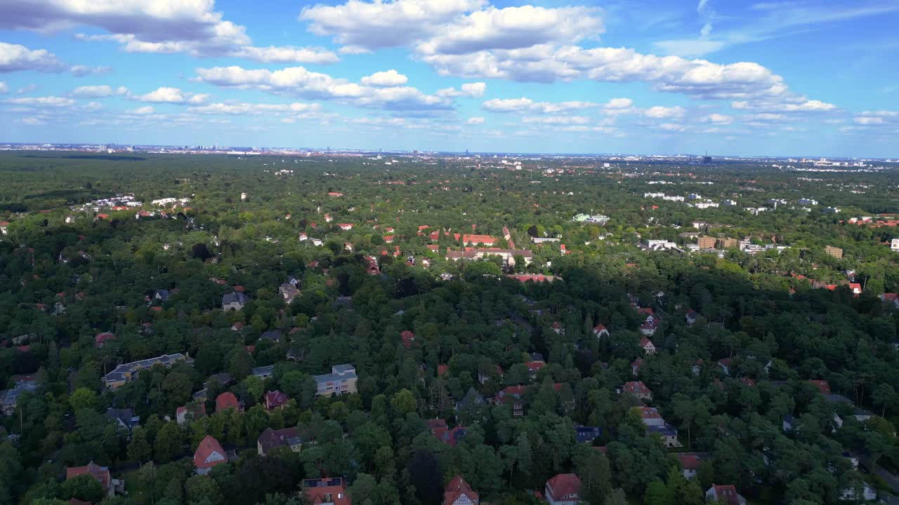 nikolassee, a residential district in berlin, featuring houses nestled within a dense forest, with the city skyline visible on the horizon. Gorgeous aerial view flight panorama overview drone