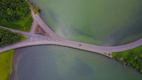 aerial top down view of road bridge between two lakes in tropical environment of azores