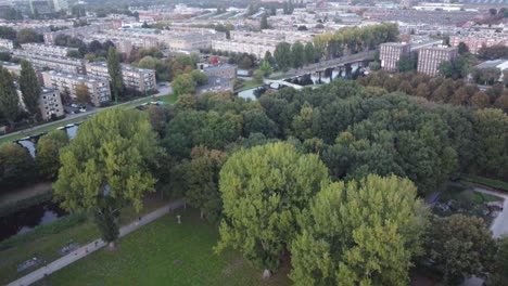 copas de árboles verdes en la esquina de un parque con un canal interior que lo rodea y personas corriendo por sus caminos en el famoso ámsterdam, vista aérea