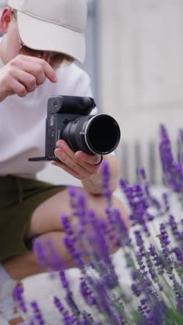 Vertical-shot-of-photographer-test-variable-ND-filter-near-lavender-shrub