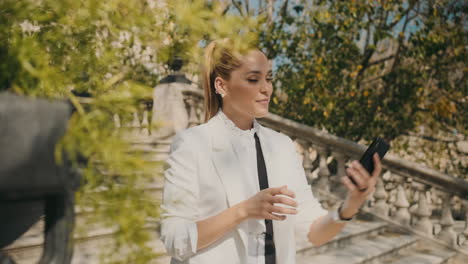 una joven elegante tomando selfies al aire libre.