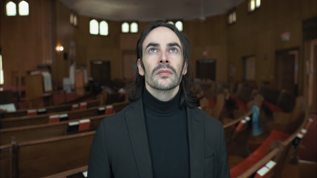 A Christian man, priest, preacher, pastor in spiritual reflection and worship while praying inside old church sanctuary, creating a cinematic and contemplative mood