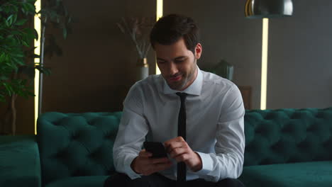 Smiling-businessman-browsing-internet-on-smartphone.-Ceo-male-using-smartphone