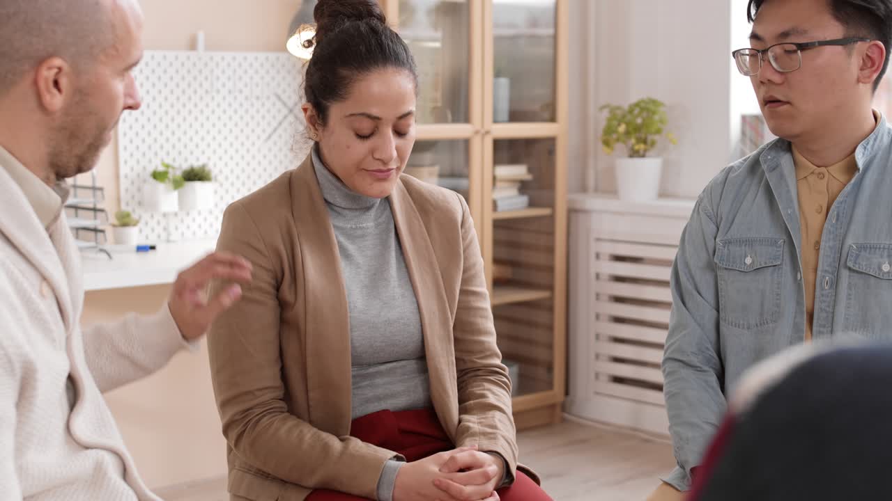 mujer desanimada hablando en una sesión de terapia de grupo