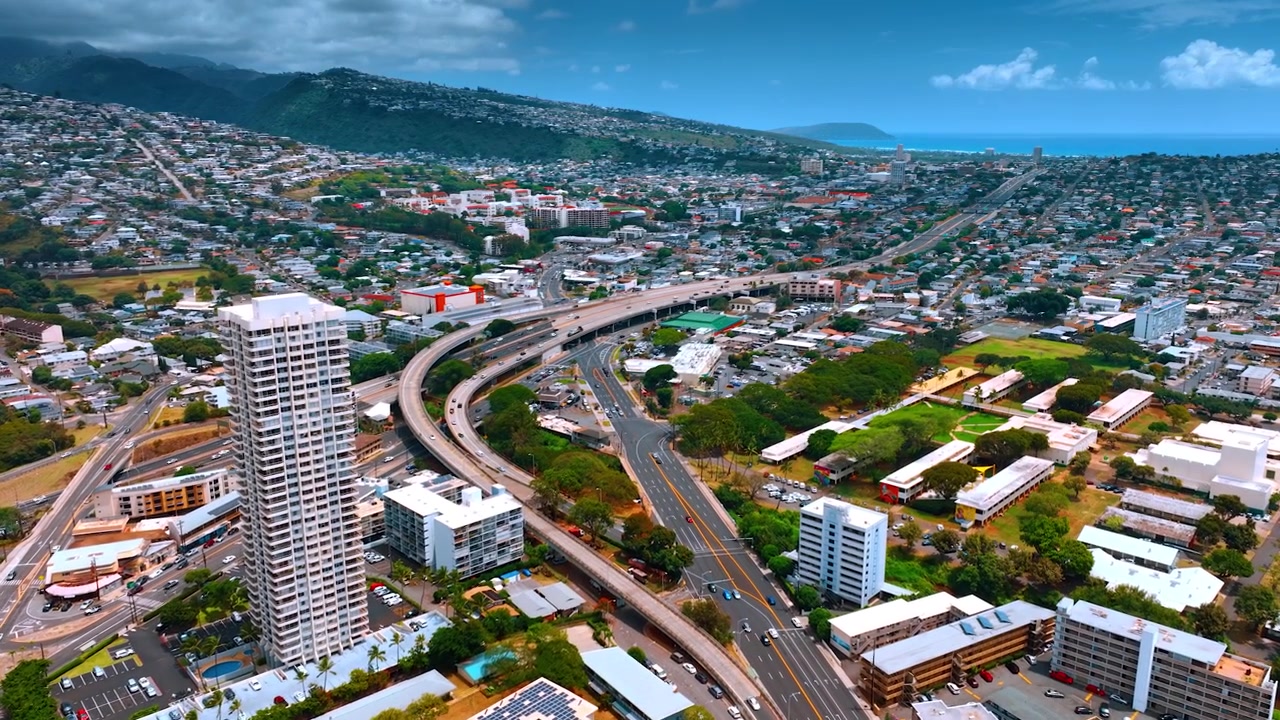 Vista sulle autostrade che attraversano il paesaggio urbano di Honolulu, Hawaii, USA. Città moderna, soleggiata e vivace vista dall'alto