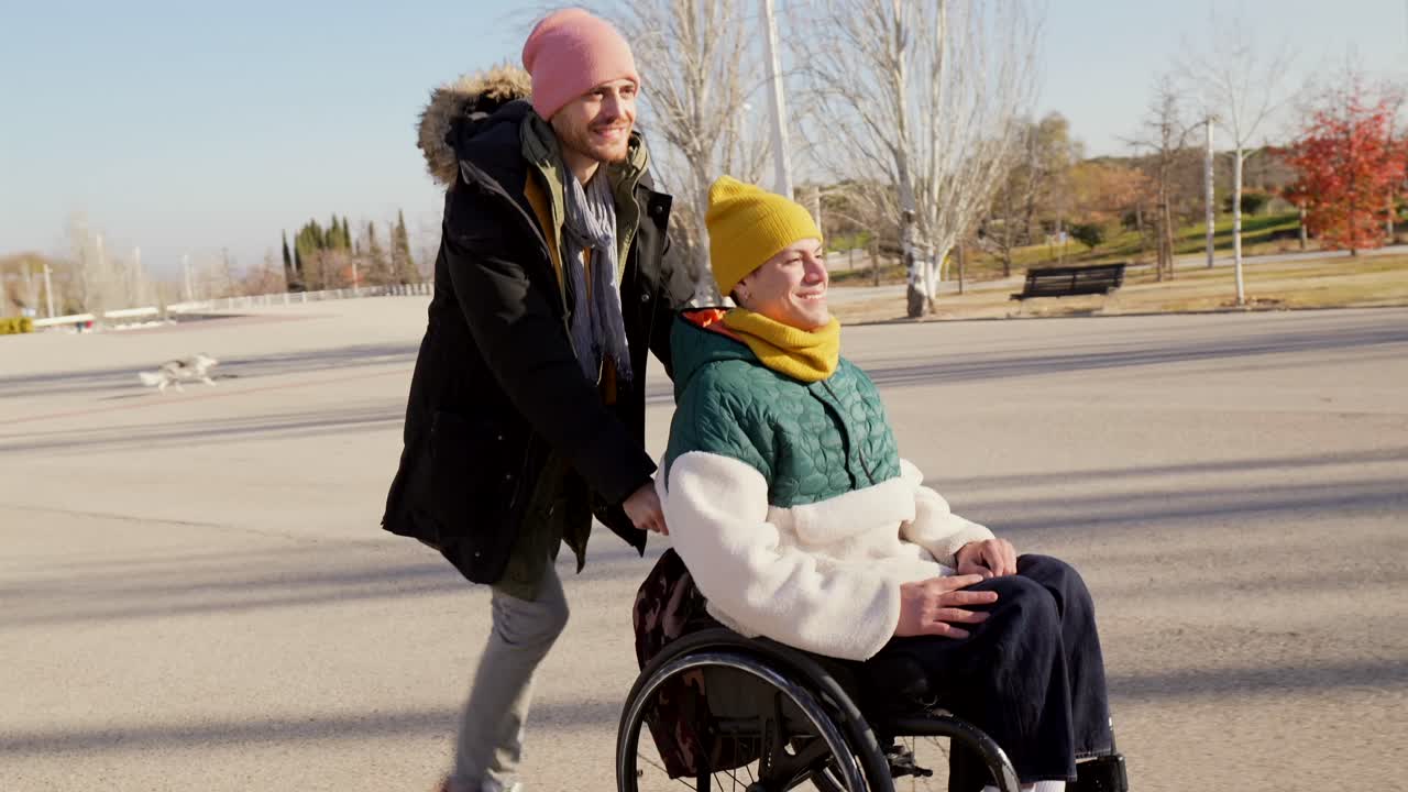 Couple enjoying a walk in the park with a wheelchair