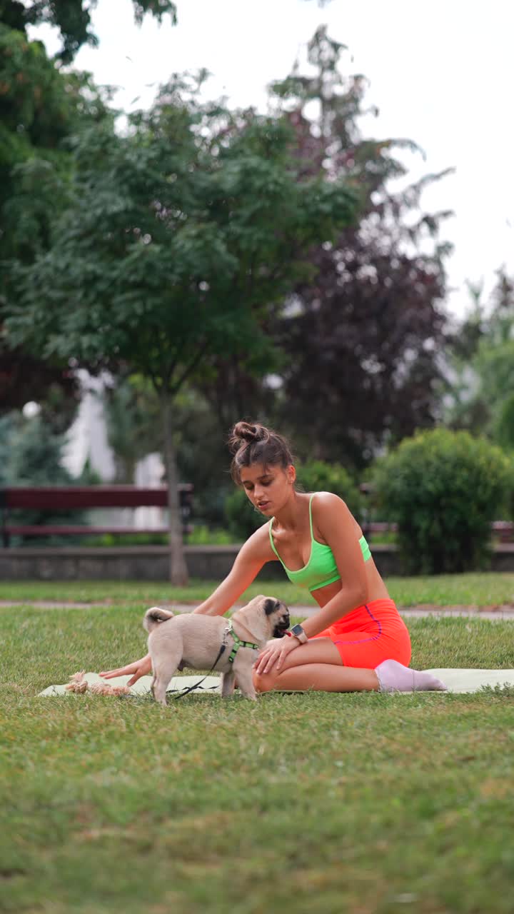 joven jugando con su perro pug en el parque