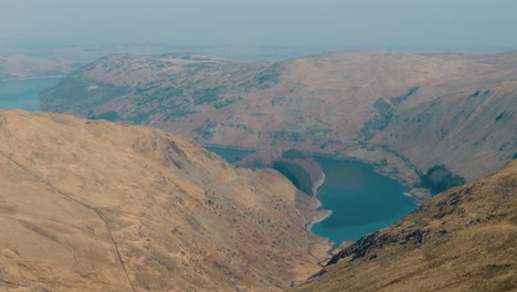 high descending circle over hazy lake district mountain lake in soft light