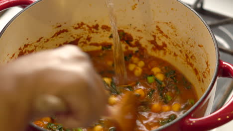 Agregando-Caldo-O-Caldo-A-La-Olla-Mientras-Prepara-Sopa-De-Garbanzos-Y-Col-Rizada