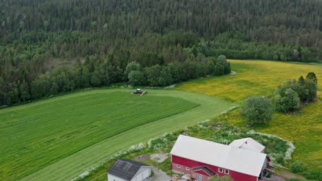 aerial view of agricultural field with working tractor in the countryside - drone shot