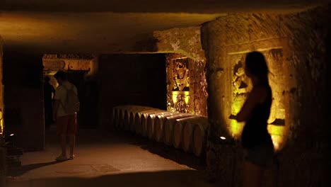 two people exploring a dimly lit winery