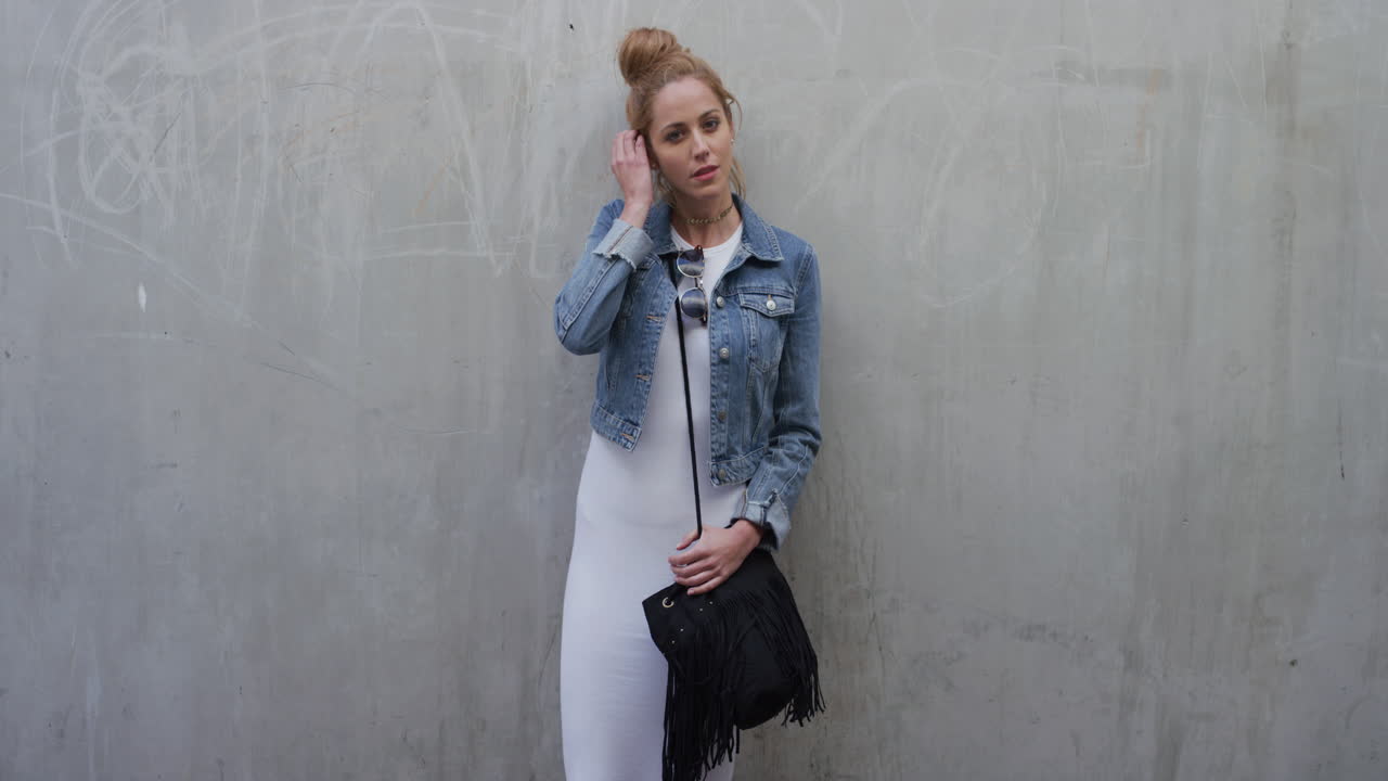 retrato de una mujer joven hermosa que se ve confiada corriendo con la mano a través del cabello vistiendo moda elegante disfrutando del estilo de vida en cámara lenta