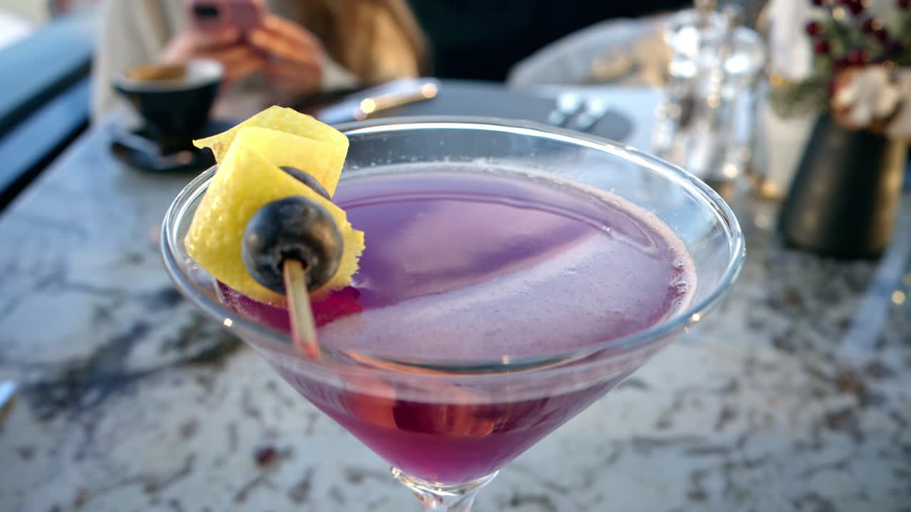 Pink red martini with blueberries on top close up