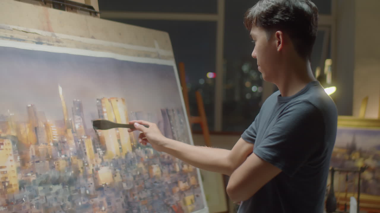 Artist Painting Nighttime City Panorama in Studio