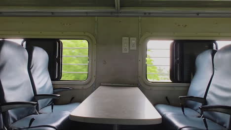 slow zoom-in on vacant seats beside window in moving indian train, tranquil ambiance of travel and solitude.