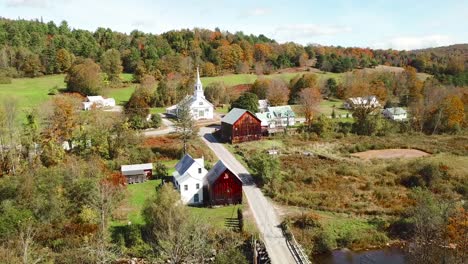 an aerial over a charming small village scene in vermont with church road and farm 3