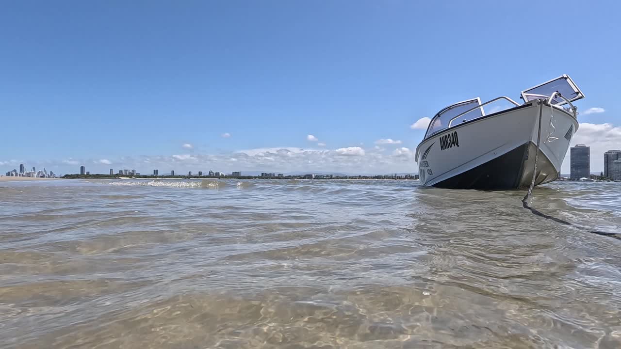 barco amarrado en la soleada playa de la costa dorada