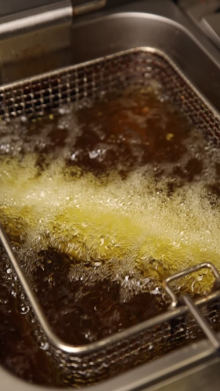 Bubbling Hot Oil Deep Frying Food in a Fryer Basket
