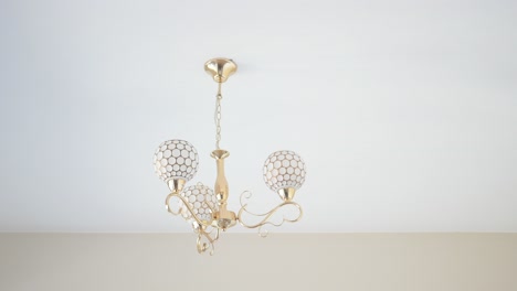 elegante candelabro de oro con sombras de globo blanco