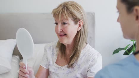 senior woman touching her hair looking in the mirror