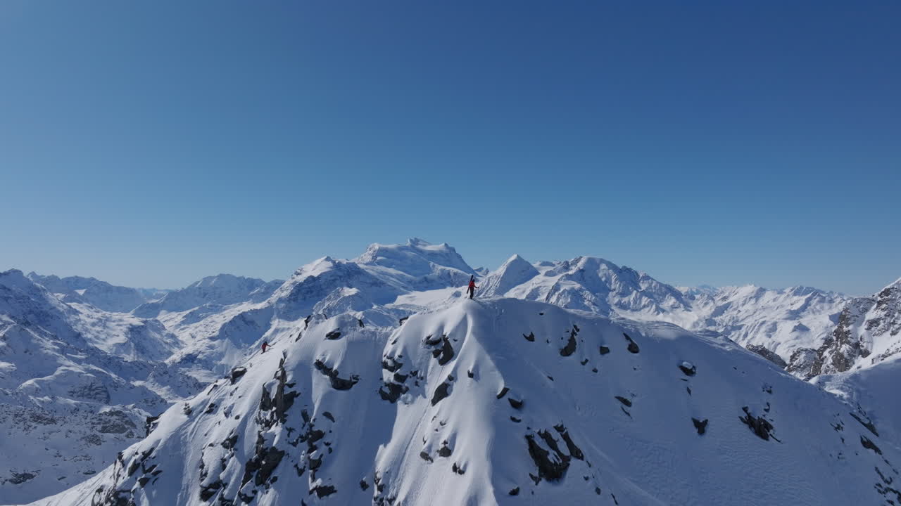 A professional skier hikes up a steep ridge in Verbier, then drops into an epic freeride descent. Pure adventure skiing in deep snow, dramatic terrain, and breathtaking alpine scenery.