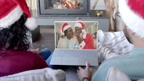 Feliz-Pareja-Diversa-Y-Padres-Mayores-Teniendo-Videollamada-Navideña-Con-Laptop,-Cámara-Lenta