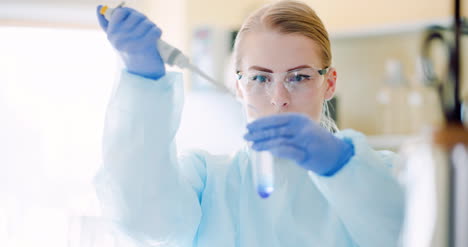 Female-Scientist-Injecting-Liquid-Or-Virus-Into-Flask-In-Laboratory