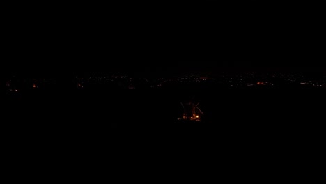 In-the-dead-of-night-the-lights-of-an-isolated-windmill-illuminates-it’s-surroundings