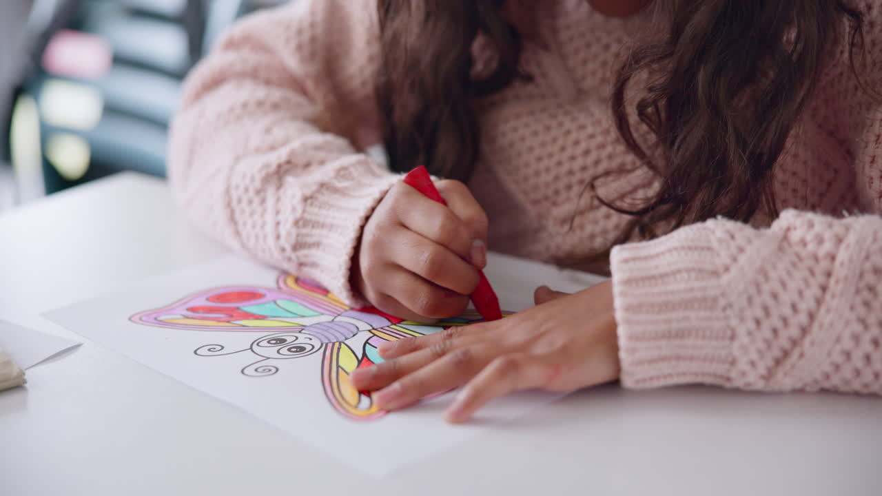 Child coloring a butterfly with a crayon