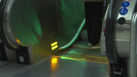 Commuter-with-bicycle-rolls-onto-escalator-going-up,-low-angle-view