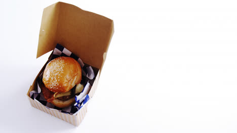 hamburger in a take away container on table