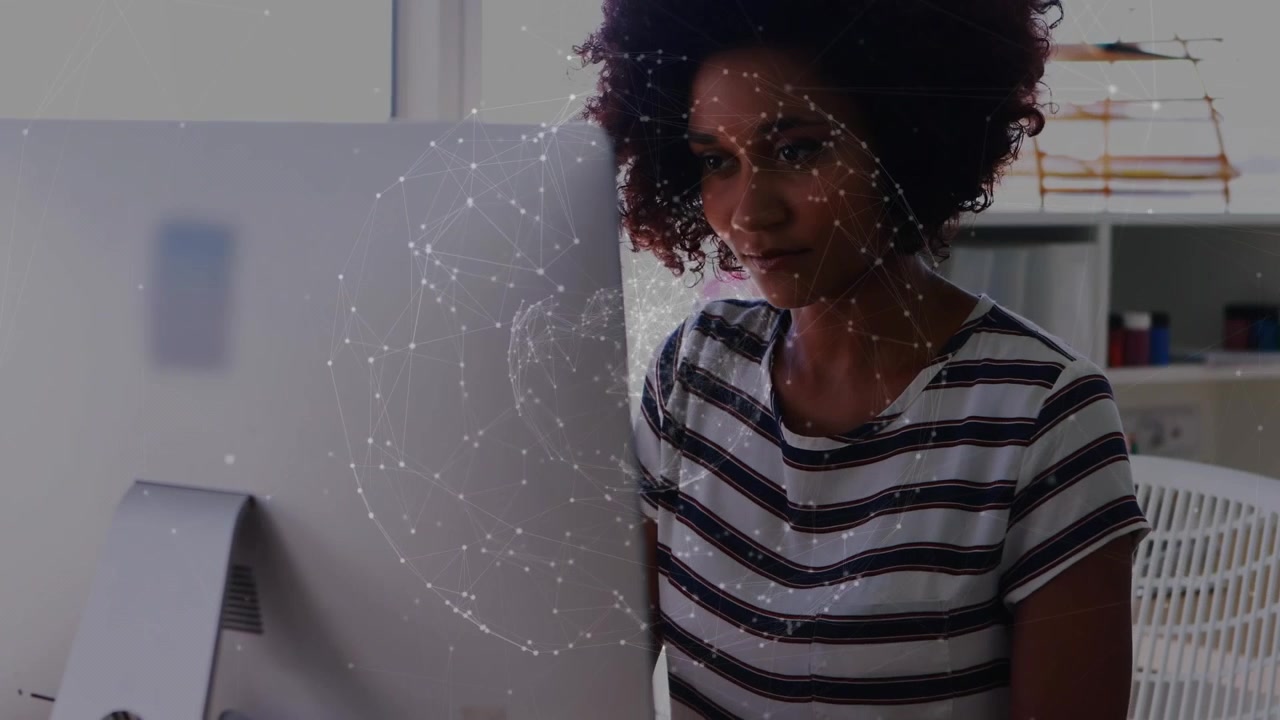 Animation of globe rotating over african american businesswoman drinking coffee and using computer