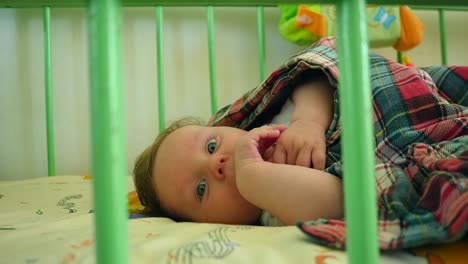 beautiful baby lying awake in crib