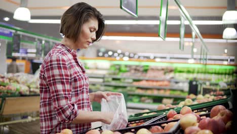 beautiful woman shopping red apples in supermarket